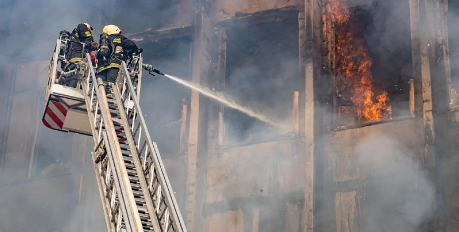 Наслідки атаки на Харків Зображення двох рятувальників, які гасять пожежу в багатоповерхівці