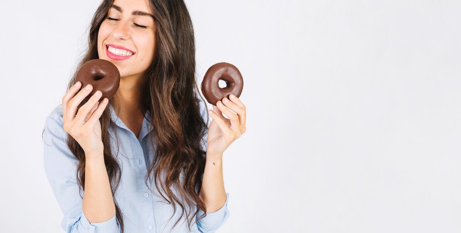 Девушка держит в руках два пончика