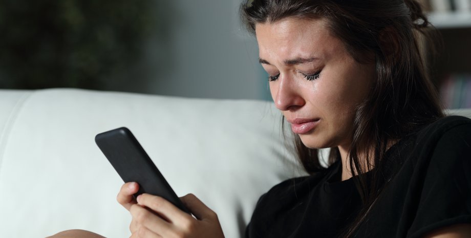 Девушка со смартфоном плачет