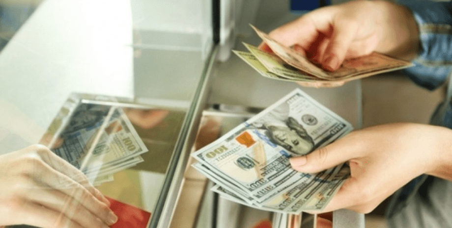 Женщина покупает доллары в обменнике