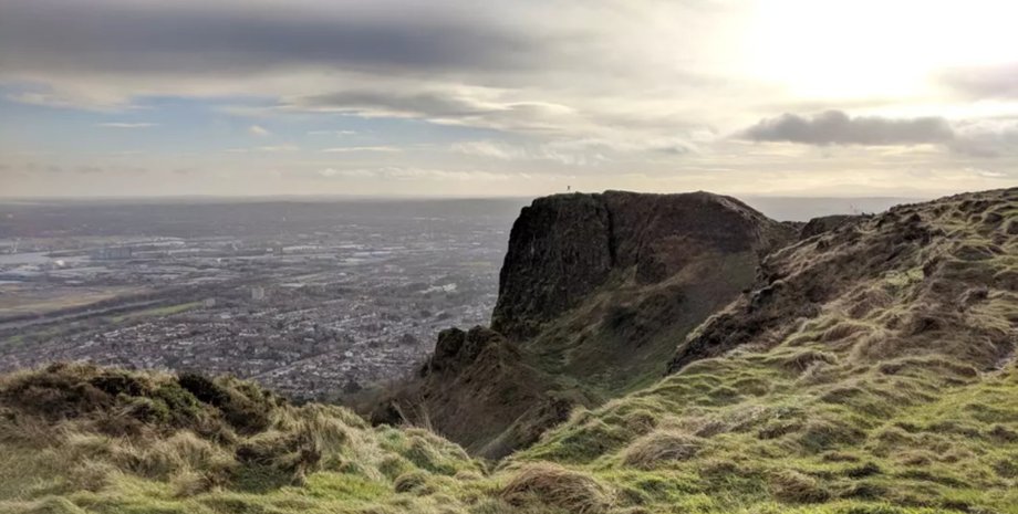 Вірусне фото, фотобомба, стрибок на скелі, Белфаст, Кейвхілл, Північна Ірландія, вдалий кадр, випадкова фотографія, людина в стрибку, незвичайний знімок