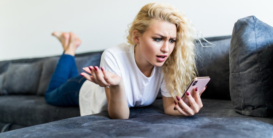 Дівчина зі смартфоном на дивані