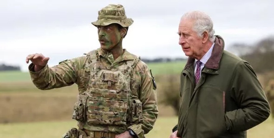 Король Великобритании Чарльз III общается с военным на учениях