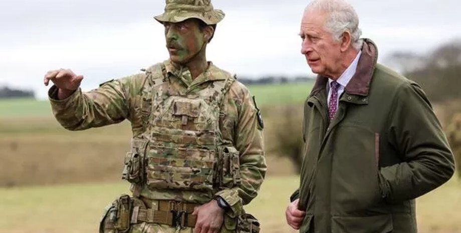 Король Великобритании Чарльз III общается с военным на учениях