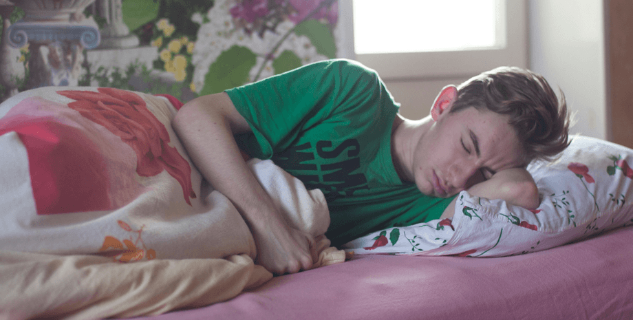 Хлопець спить у ліжку