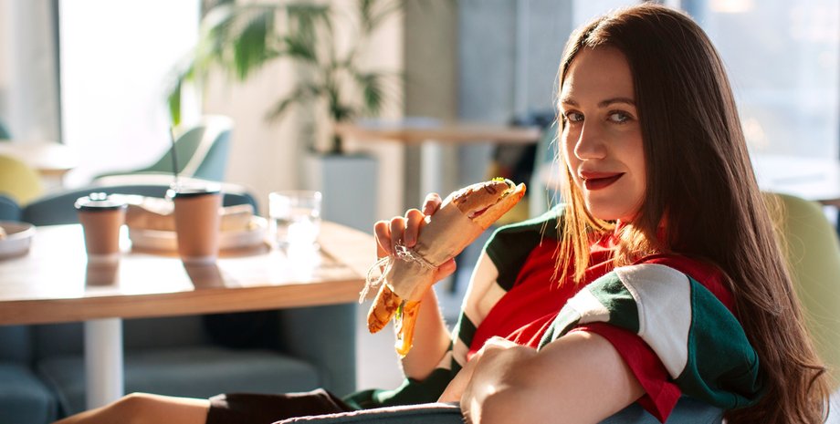 Девушка держит в руках хот-дог