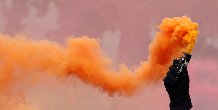 Фальшфейер в руке демонстранта в Париже, 1 мая 2018 / Фото: Reuters