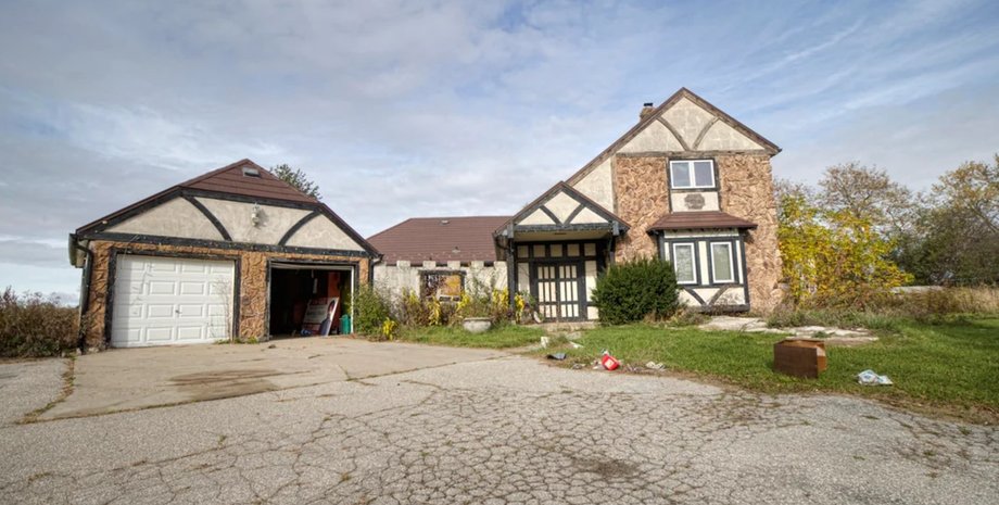 Фасад покинутого тюдорівського особняка в Онтаріо, двоповерховий будинок з окремим гаражем