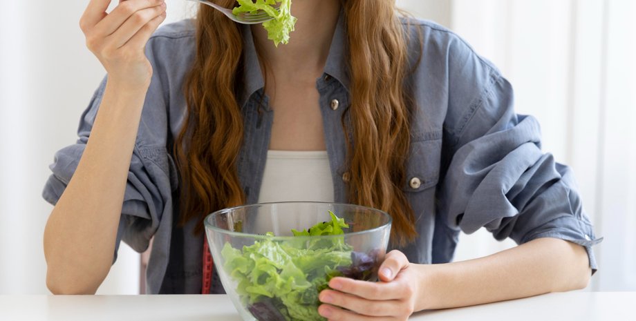 Девушка есть зеленый салат