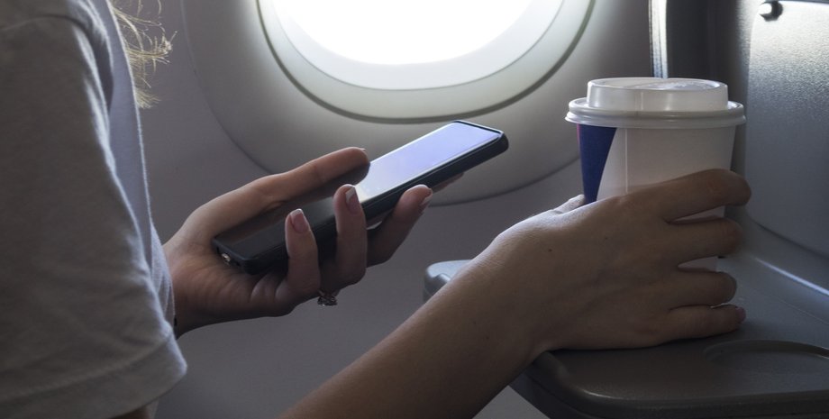 Дівчина зі смартфоном у літаку