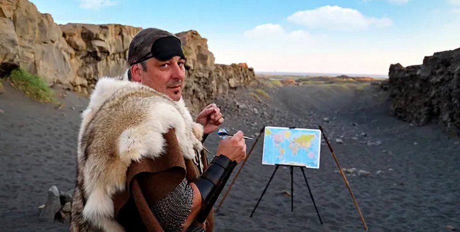 Кидає дротик у карту із зав'язаними очима