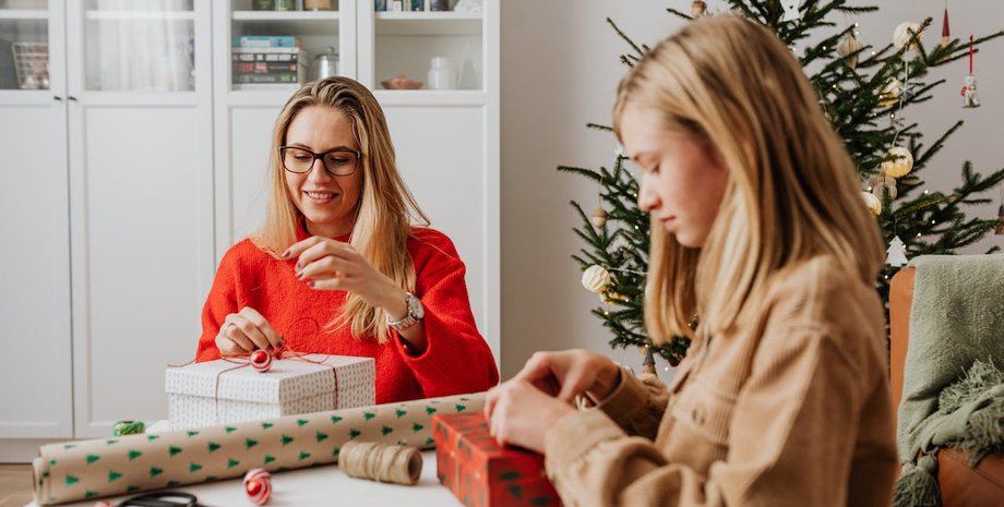 Мати і дочка запаковують подарунки