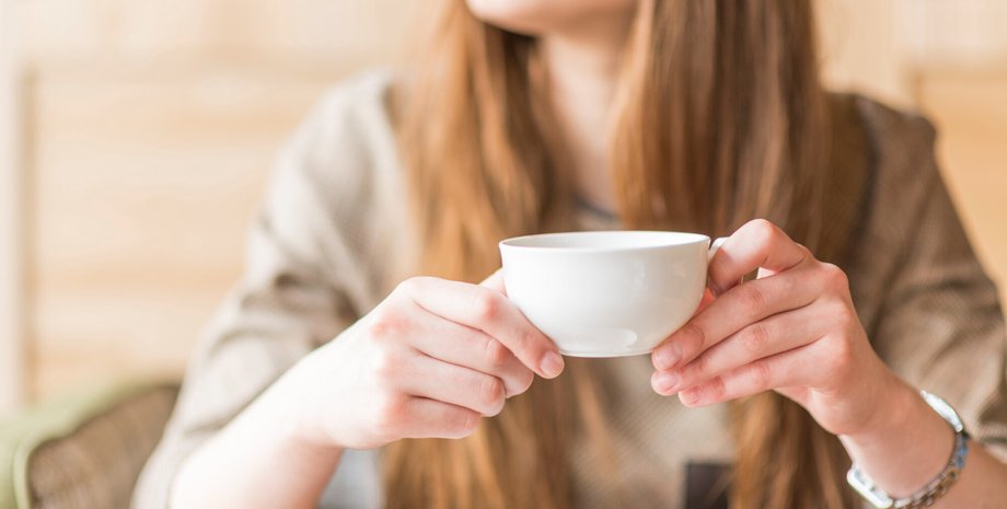 Девушка держит чашку с кофе