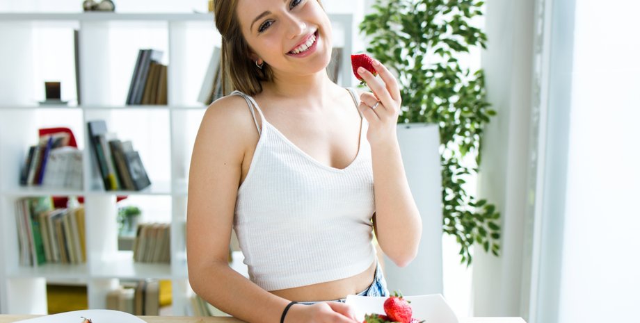Девушка держит тарелку с клубникой в руках