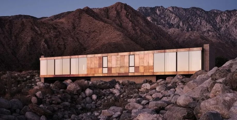 Современная вилла посреди пустыни с мостом и бассейном в скалах