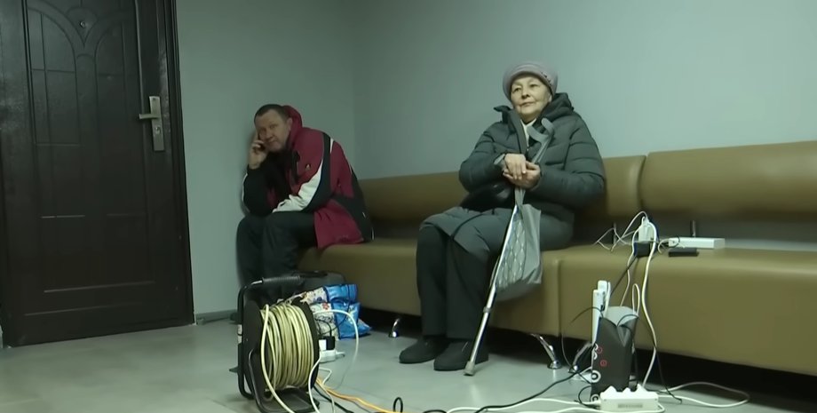 Мужчина и женщина во время блэкаута заряжают гаджеты во время блэкаута