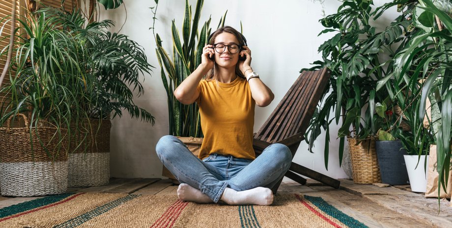 Дівчина сидить на підлозі серед квітів