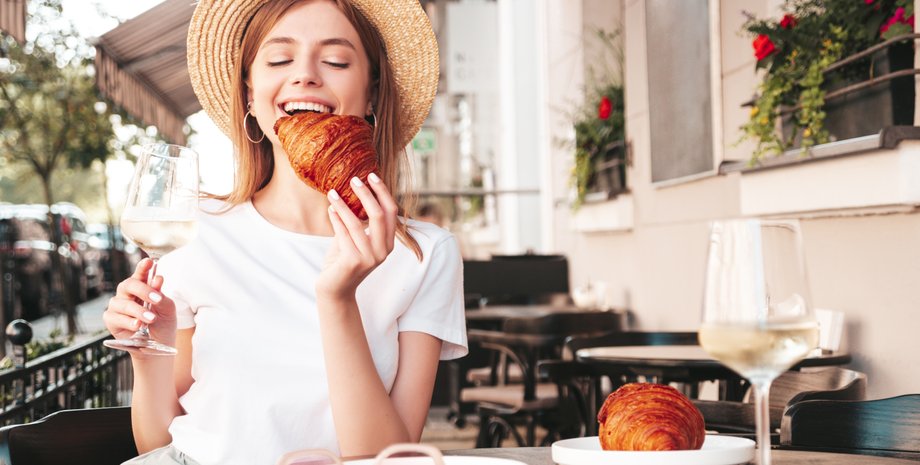 Дівчина їсть круасан