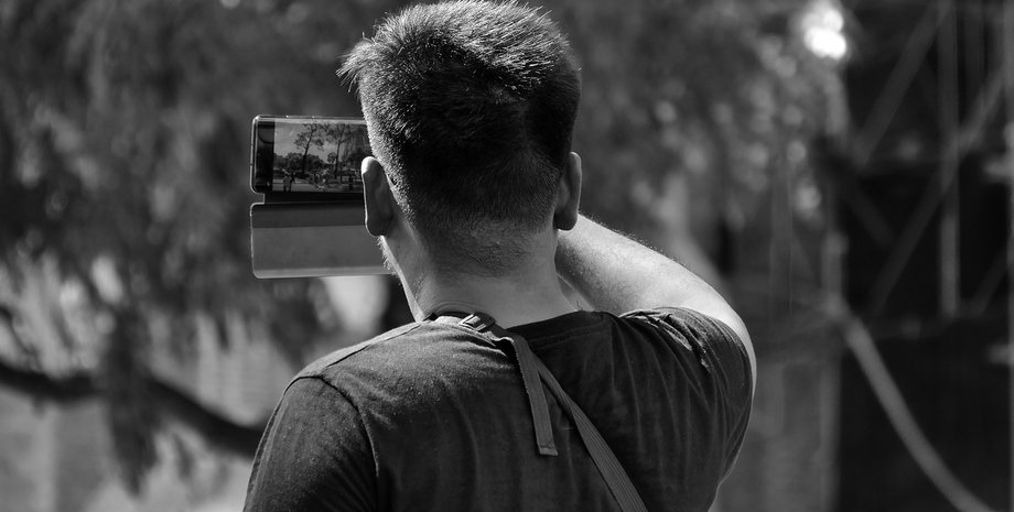 Мужчина делает селфи на смартфон на природе