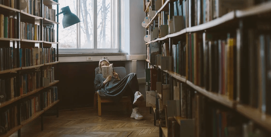 Девушка читает книгу, библиотека, книги, полки с книгами, читали одну книгу 28 лет, обсуждение романа, книжный клуб