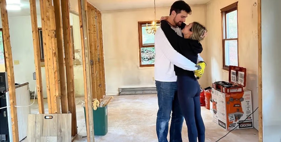 Молода пара обіймається в недобудованій кімнаті під час ремонту будинку в Коннектикуті