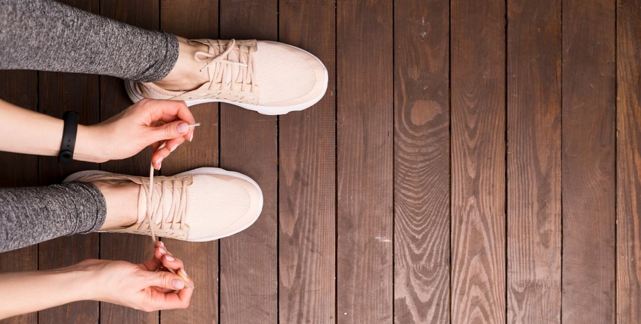Девушка зашнуровывает кроссовок