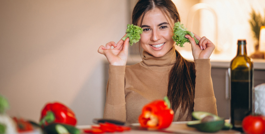 Овощи на кухне Девушка на кухне с овощами