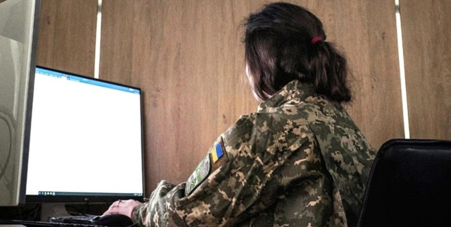 Девушка в военной форме перед компьютером