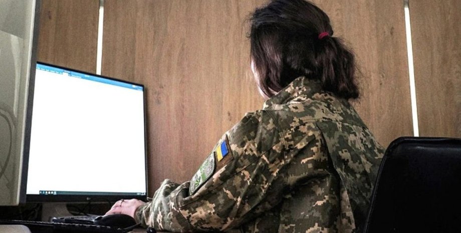 Девушка в военной форме перед компьютером