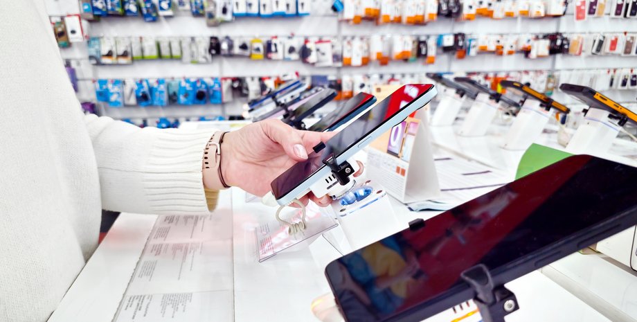 Девушка осматривает смартфон в магазине