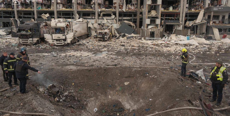 спасатели рассматривают воронку от ракетного удара по Киеву