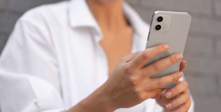 Женщина держит смартфон без чехла