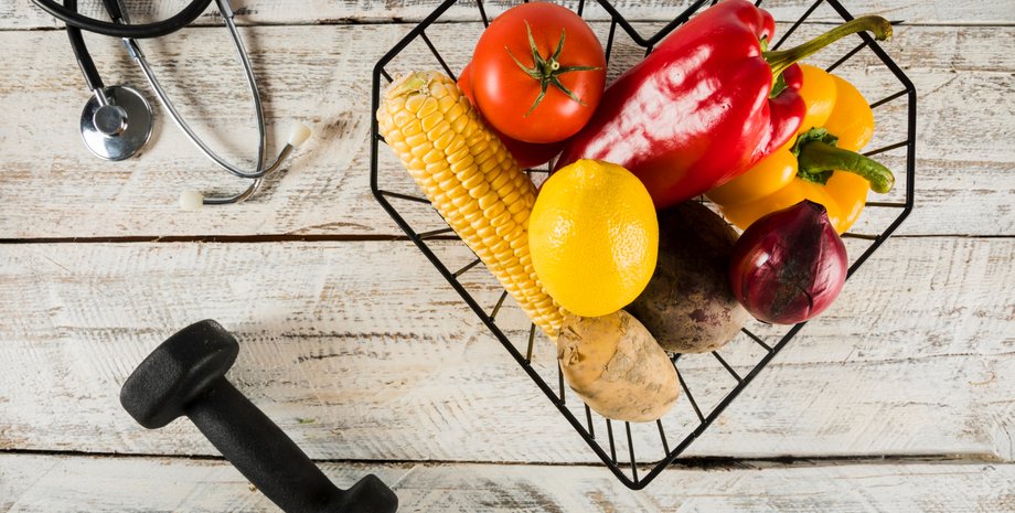 Свежие фрукты и овощи на стол возле гантели и стетоскопа