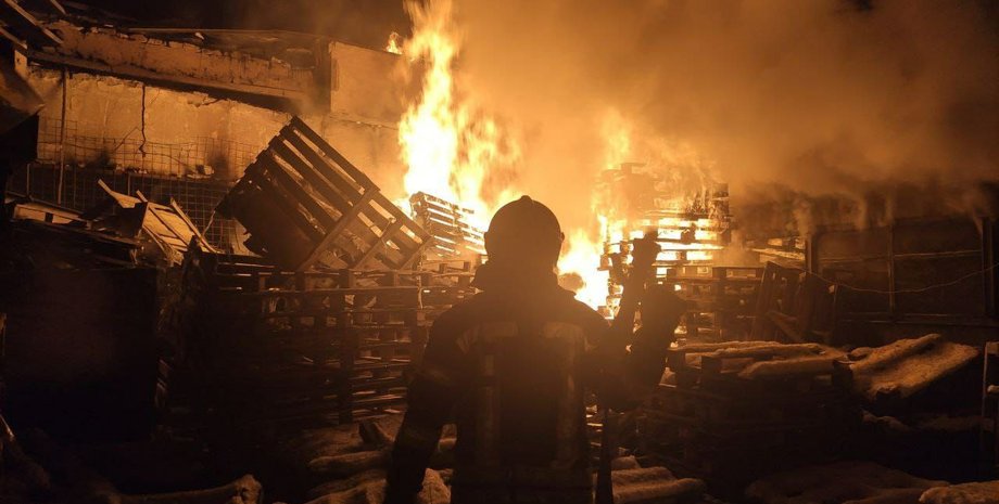 Сотрудник ГСЧС на фоне поврежденного объекта