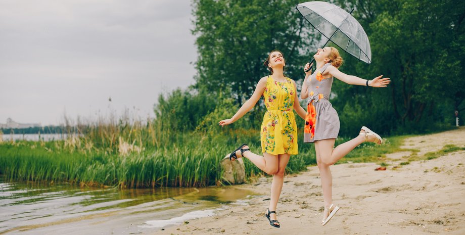 Женщины с зонтиком у реки