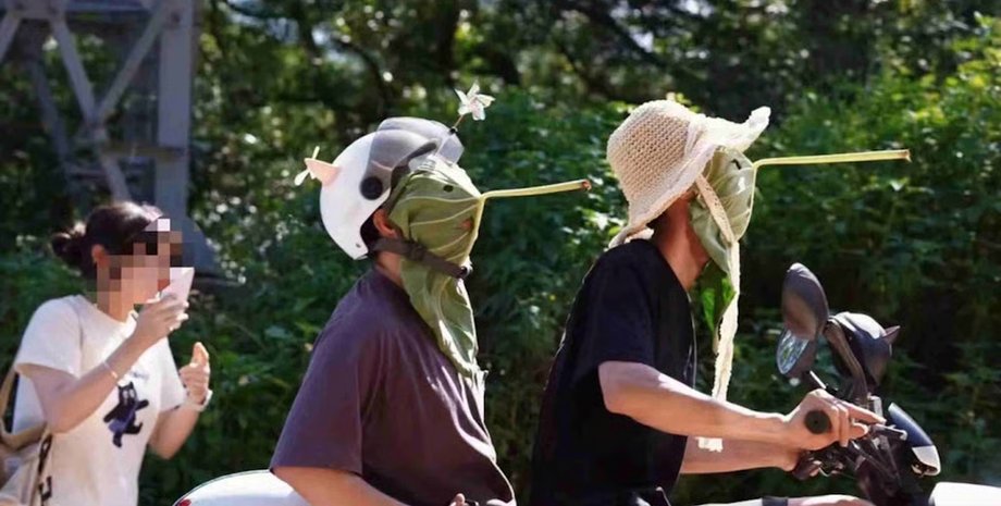 Китайцы в масках с длинным носом, сделанных из листьев лотоса