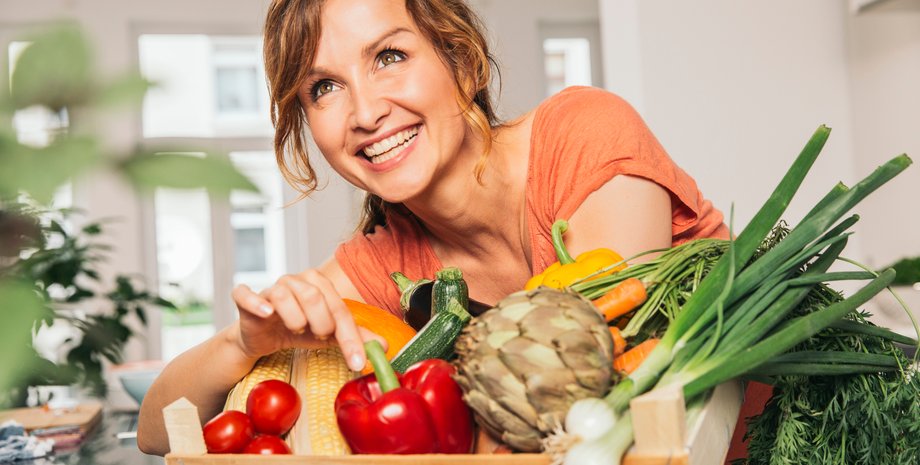 Женщина с ящиком свежих овощей