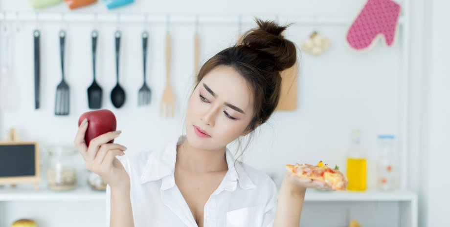 Дівчина обирає між яблуком і піцою