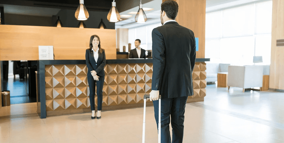 Мужчина с чемоданом заходит в отель