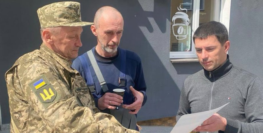 фото с военным ТЦК, который вручает повестку военнообязанному