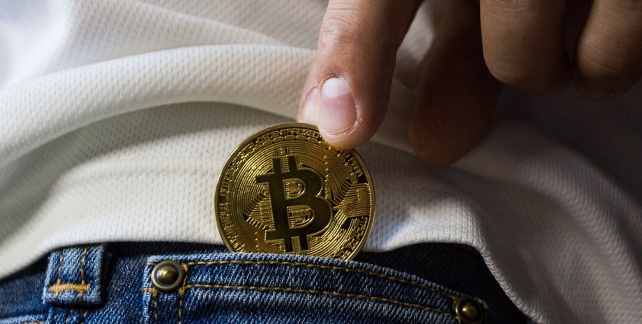 Біткоїн Чоловік ховає монету Біткоїн у кишеню