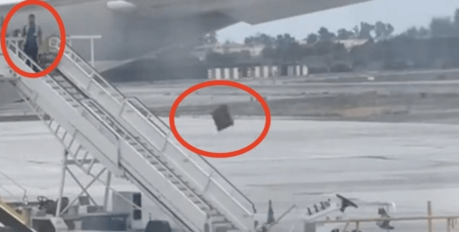 Співробітник наземного персоналу Qatar Airways жбурляє багаж із трапа літака в аеропорту Мадрида