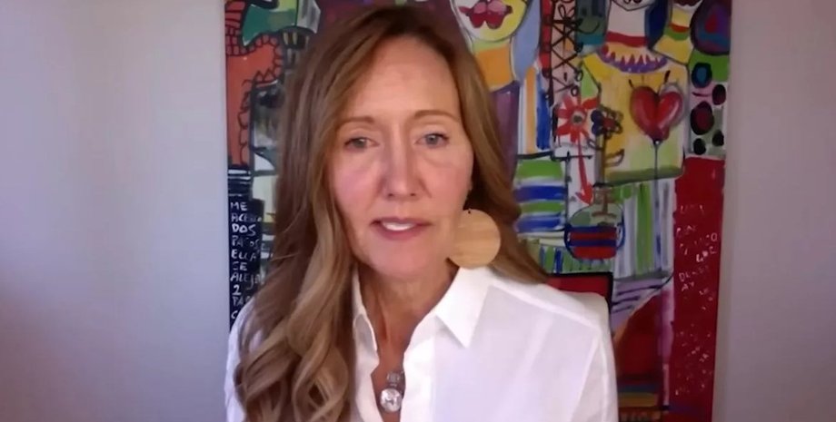 Женщина из Канады, описывающая свой внетелесный опыт, сидит перед абстрактной картиной