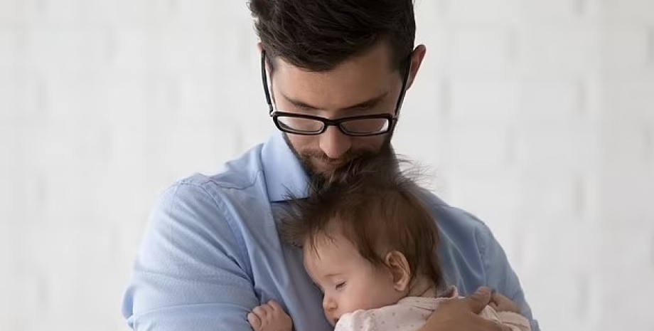 Зображення чоловіка, який тримає на руках дитину