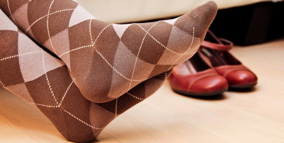 Пара ніг у шкарпетках з візерунком, шкарпетки збирають мільйони бактерій і потребують регулярного прання та заміни