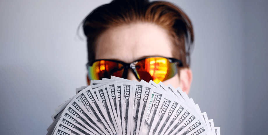 Монеты биткоина на фоне долларов как символ потенциальной прибыли от инвестиций