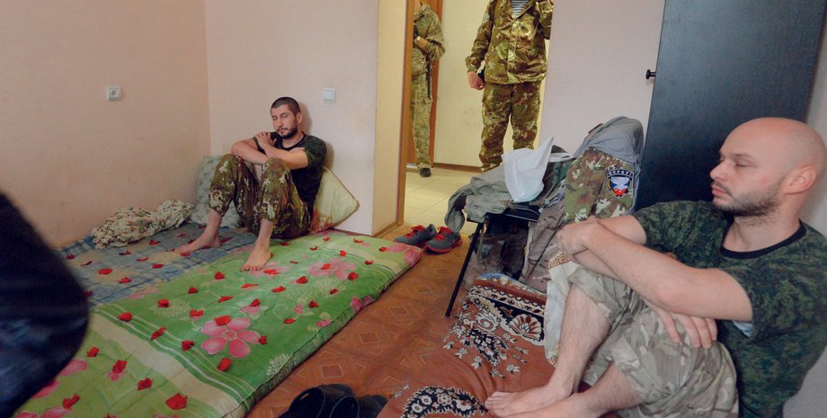 Террорист Игорь Безлер показывает журналистам пленных / AFP