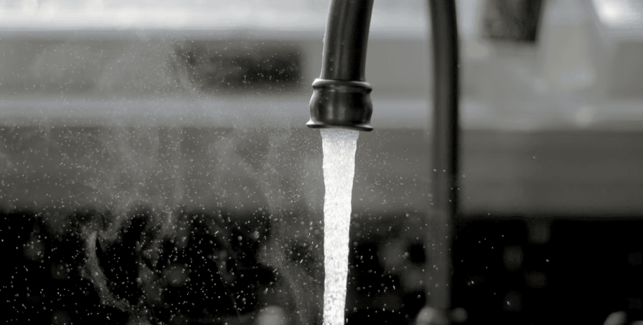 Кухонный кран с капающей водой, которая превратилась в лед во время сильных морозов