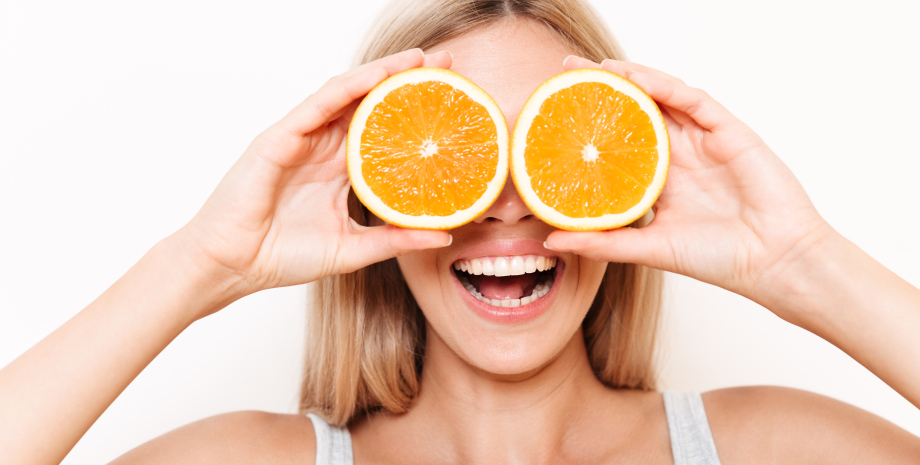 Девушка держит апельсины