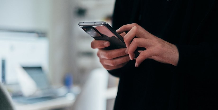 чоловік зі смартфоном у руках чоловік тримає смартфон